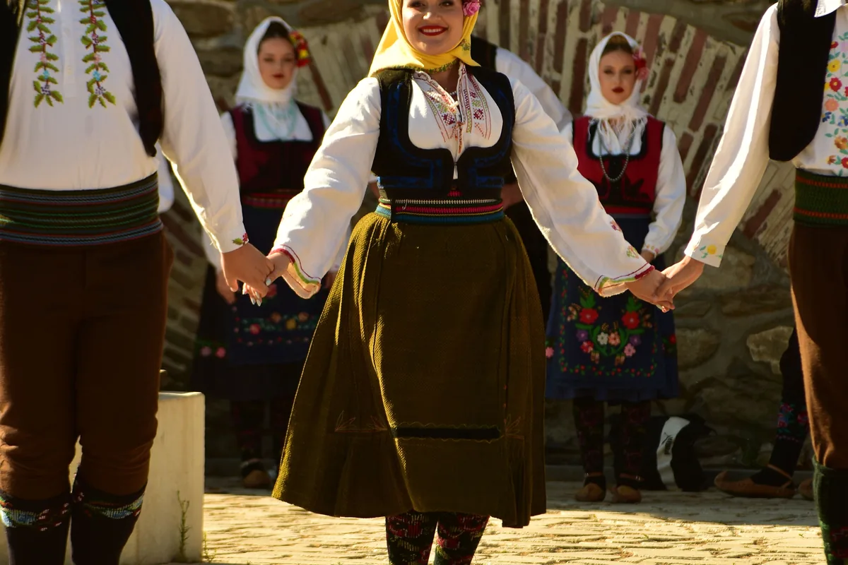 Tanečníci v barevných tradičních kostýmech vystupující venku, ilustrující folklorní tanec obecně
