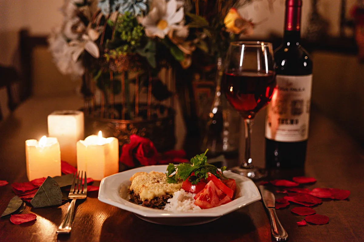 Stůl prostřený ke svíčkové večeři s vínem, ilustrující večerní jídlo v restauraci